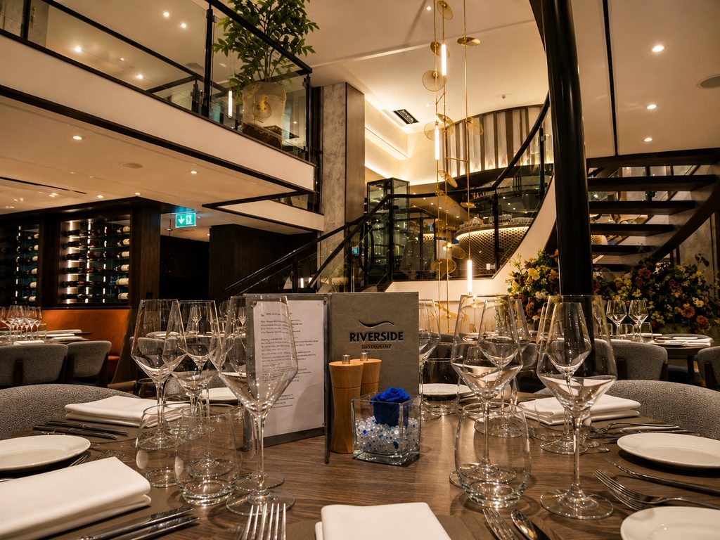 Elegantes Riverside-Restaurant mit gedecktem Tisch